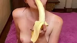 Hot brunette enjoys sucking banana