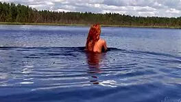 Naked redhead teen plays with water lily