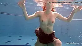 big tits brunette mia strips naked underwater in the pool, showing off her shaved body