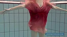 katya okuneva steps into the pool in a red dress, enjoying the outdoor beach scene underwater