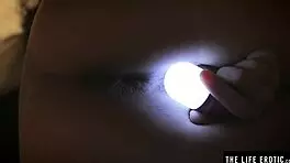 Sleepless girl rubs her trimmed clit under handheld light at night.