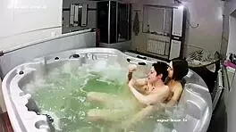 Young lesbian couple bathes intimately, fingers exploring in jacuzzi