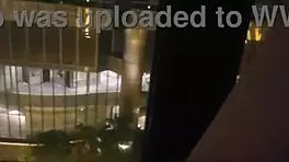 Milf masturbates in front of hotel window.