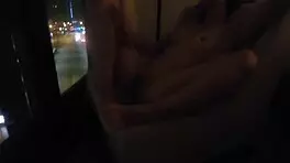 Milf masturbates in front of hotel window.