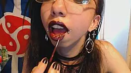 young goth applies dark red lipstick and teases huge puffy nipples