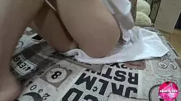 A cute teen fingers herself while parents watch TV nearby.