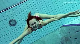 Anna netrebko teases in bikini while swimming in the pool, showing off her petite figure.