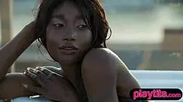 Petite ebony milf feels the thrill of stripping in the pool to show her juicy round tits.