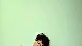 On a sunny day, this horny young teen masturbates with a big cock on the bed, getting cum covered.