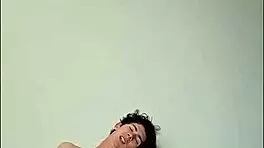 On a sunny day, this horny young teen masturbates with a big cock on the bed, getting cum covered.