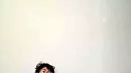 On a sunny day, this horny young teen masturbates with a big cock on the bed, getting cum covered.