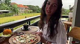 Enjoying a mouthful of pizza on the street in a public cafe with beautiful teen