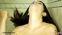 Smoldering brunette beauty enjoys a relaxing shower